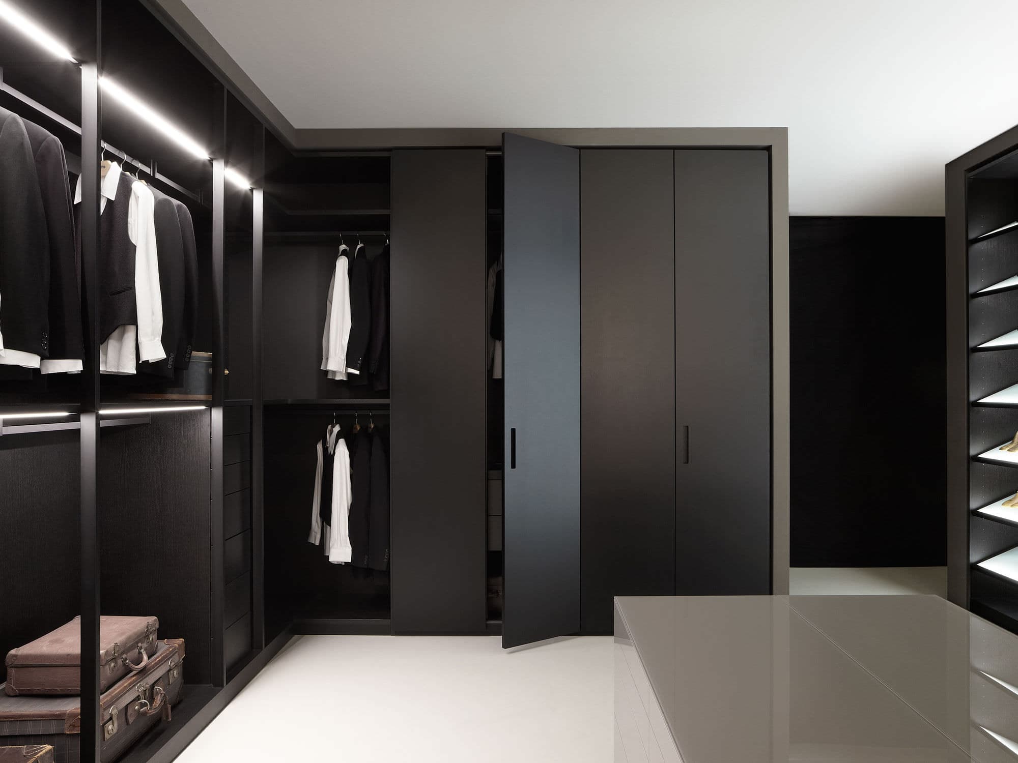 Elegant black walk-in closet by Evolux Cabinets