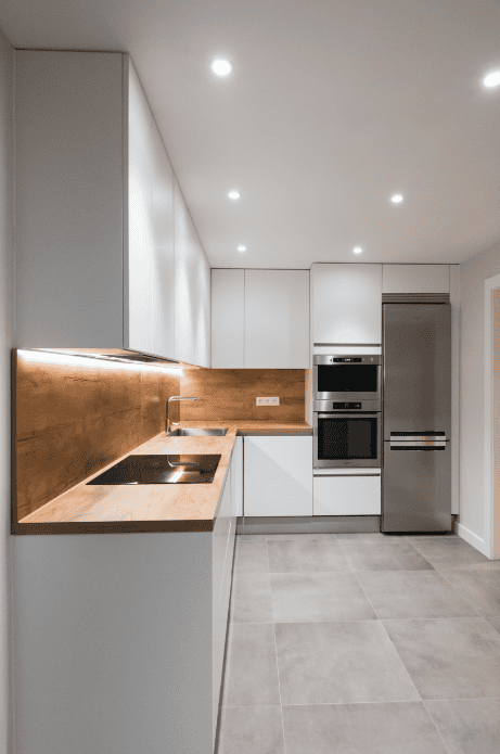 Modern minimalist indoor kitchen with white waterproof PVC cabinets by Evolux Cabinets.