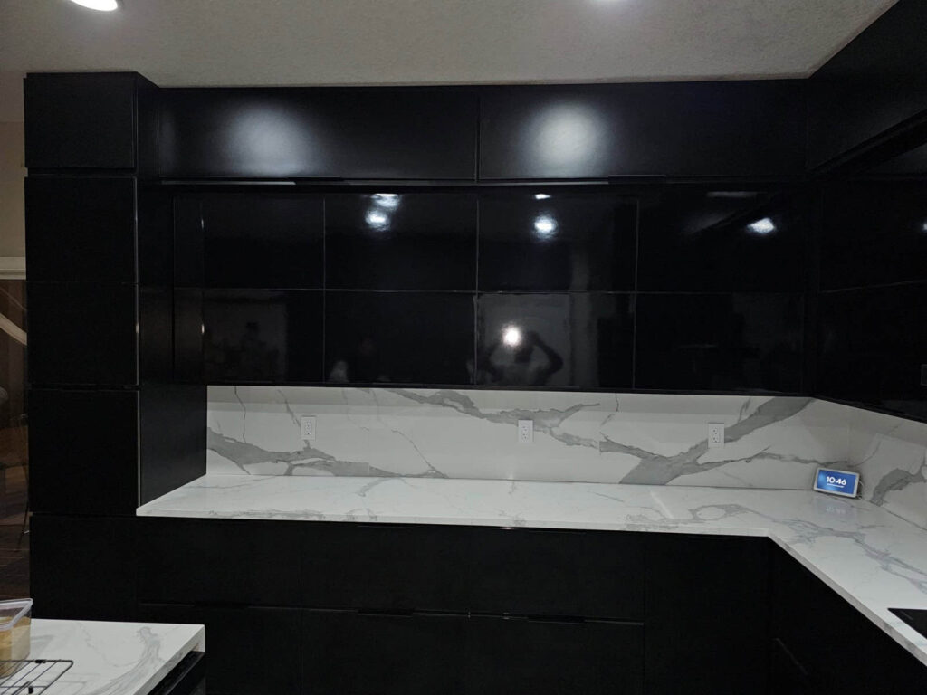 Modern black waterproof PVC kitchen cabinets designed by Evolux Cabinets in Brevard County Florida with marble-style countertops.