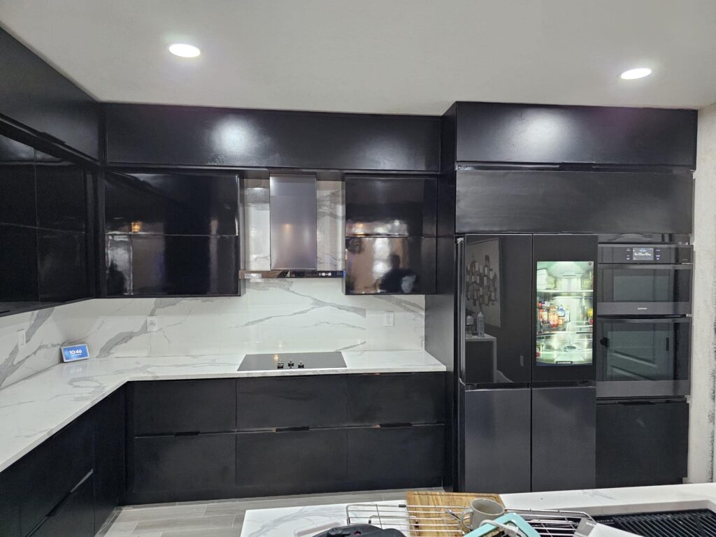 Modern black waterproof PVC kitchen cabinets designed by Evolux Cabinets in Brevard County Florida with marble-style countertops.