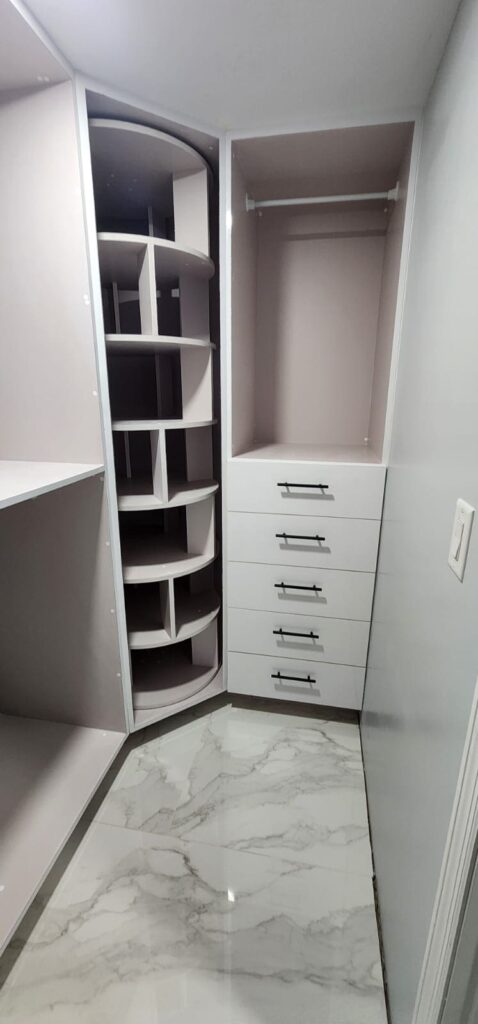 Corner closet with rotating shoe rack and drawers made of waterproof PVC by Evolux Cabinets.