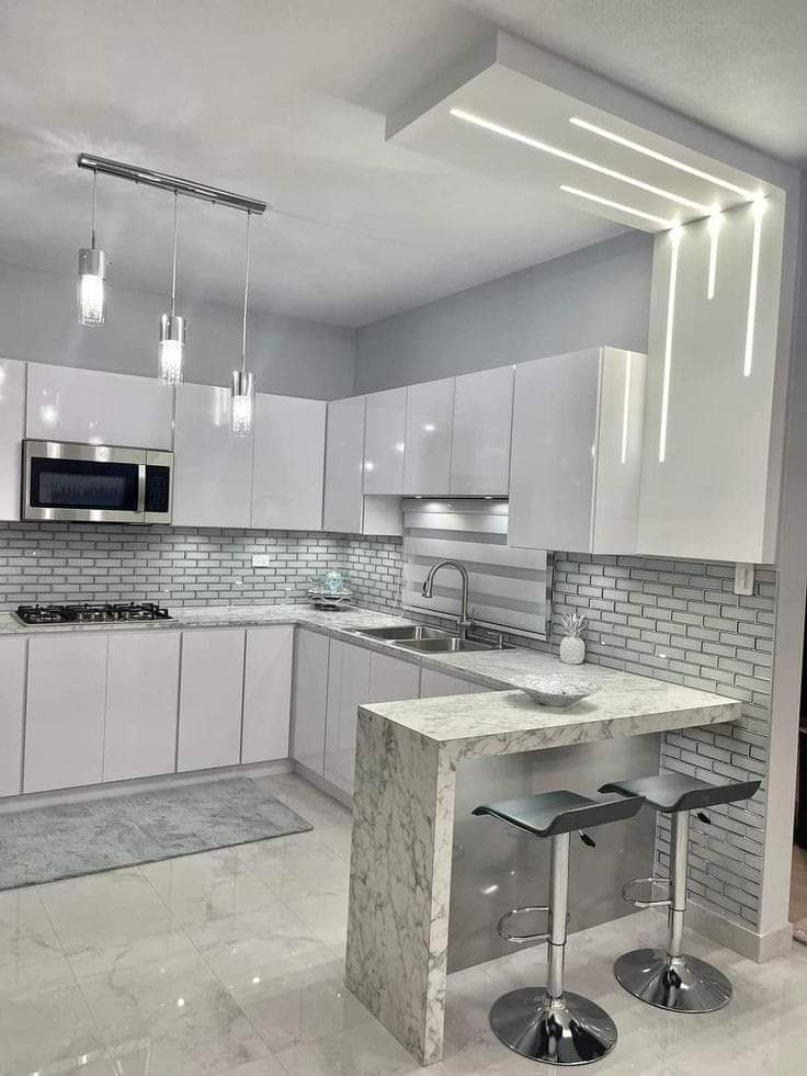 Modern indoor kitchen with high-gloss white cabinets, and integrated LED lighting. Designed and built by Evolux Cabinets.