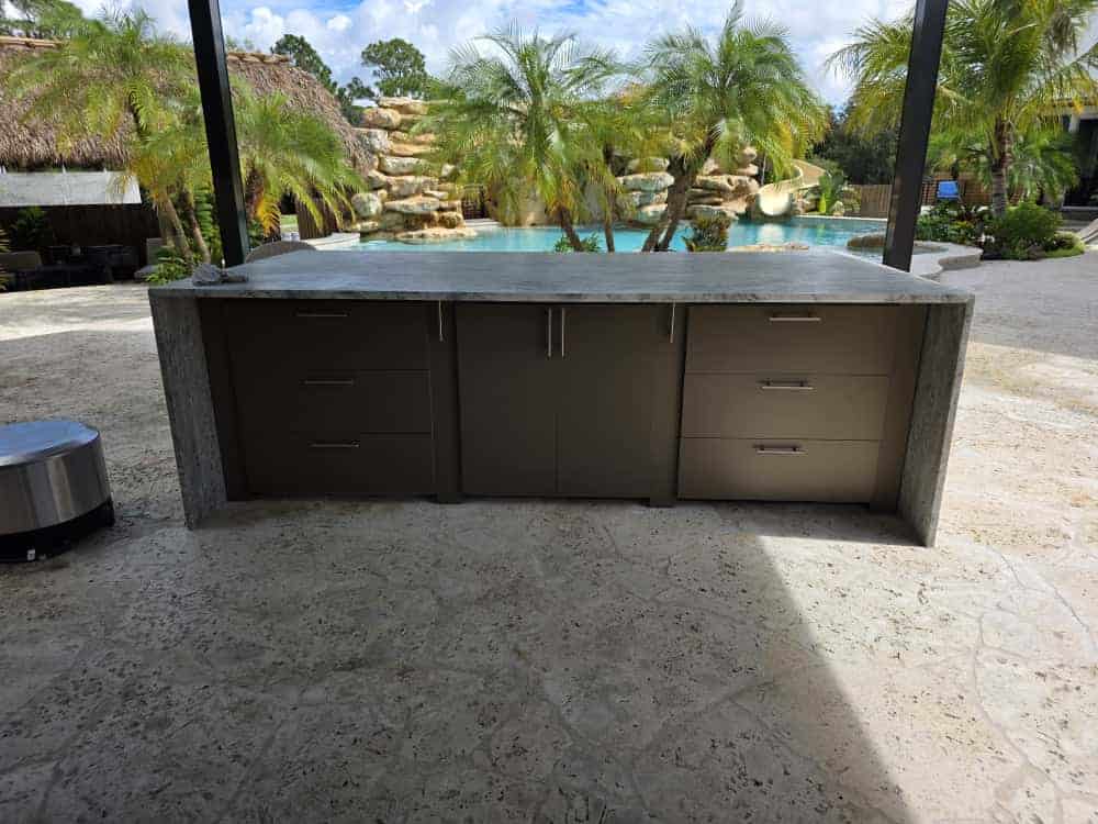 Outdoor kitchen island with taupe PVC and StarBoard waterproof cabinets and quartz countertop. Designed and built by Evolux Cabinets