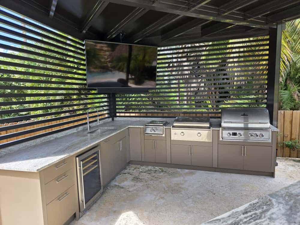 Outdoor kitchen with taupe PVC and StarBoard waterproof cabinets, quartz countertop, and Blazer stainless steel appliances. Designed and built by Evolux Cabinets for luxury outdoor living.