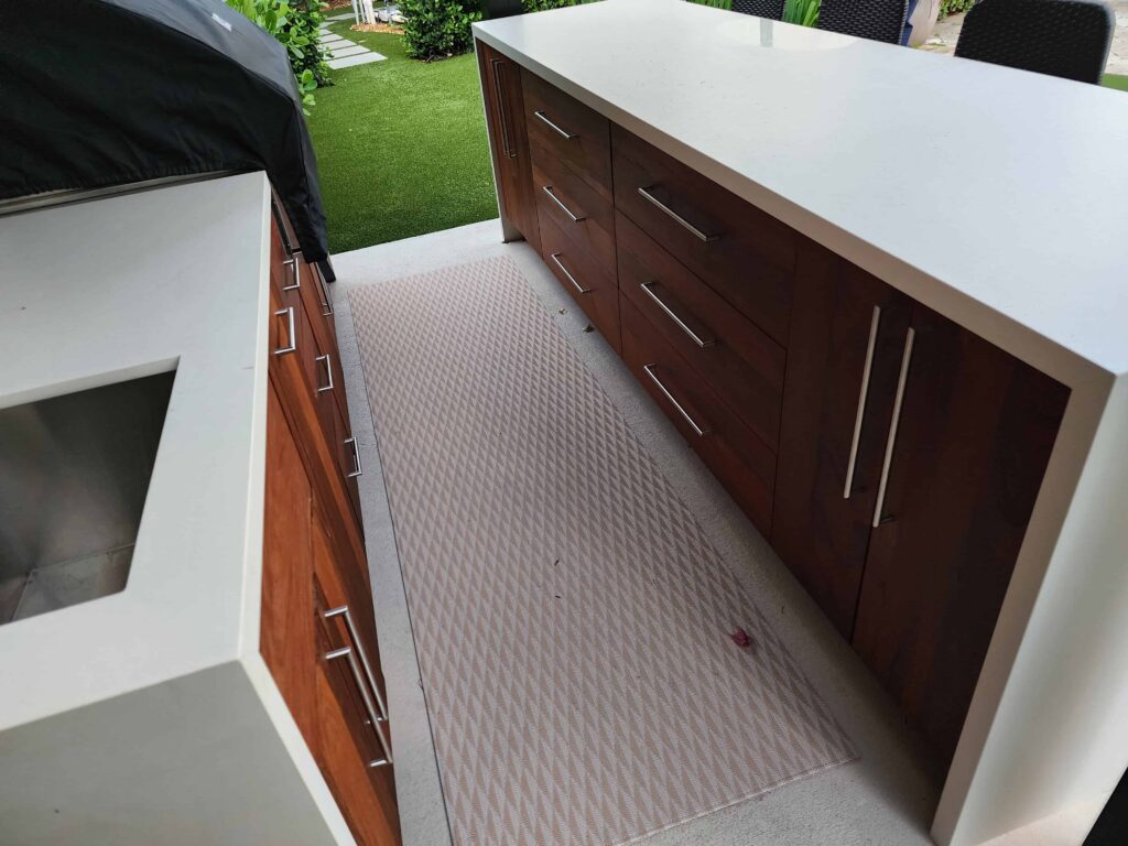 Custom outdoor kitchen with PVC waterproof cabinets, Ipe wood fronts, and quartz countertop. Designed and built by Evolux Cabinets for a unique client project.