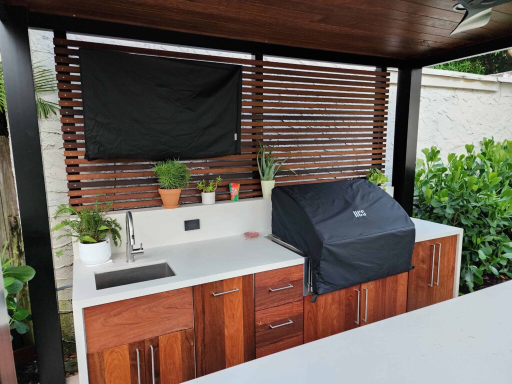 Custom outdoor kitchen with PVC waterproof cabinets, Ipe wood fronts, and quartz countertop. Designed and built by Evolux Cabinets for a unique client project.