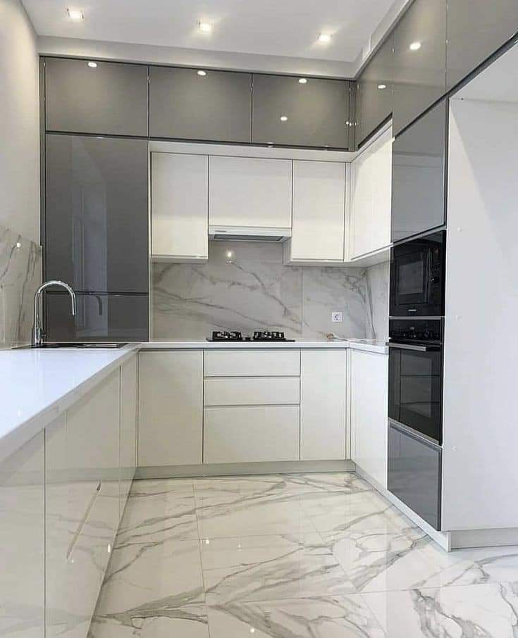 Modern white and gray PVC kitchen with marble backsplash and waterproof cabinets by Evolux Cabinets.
