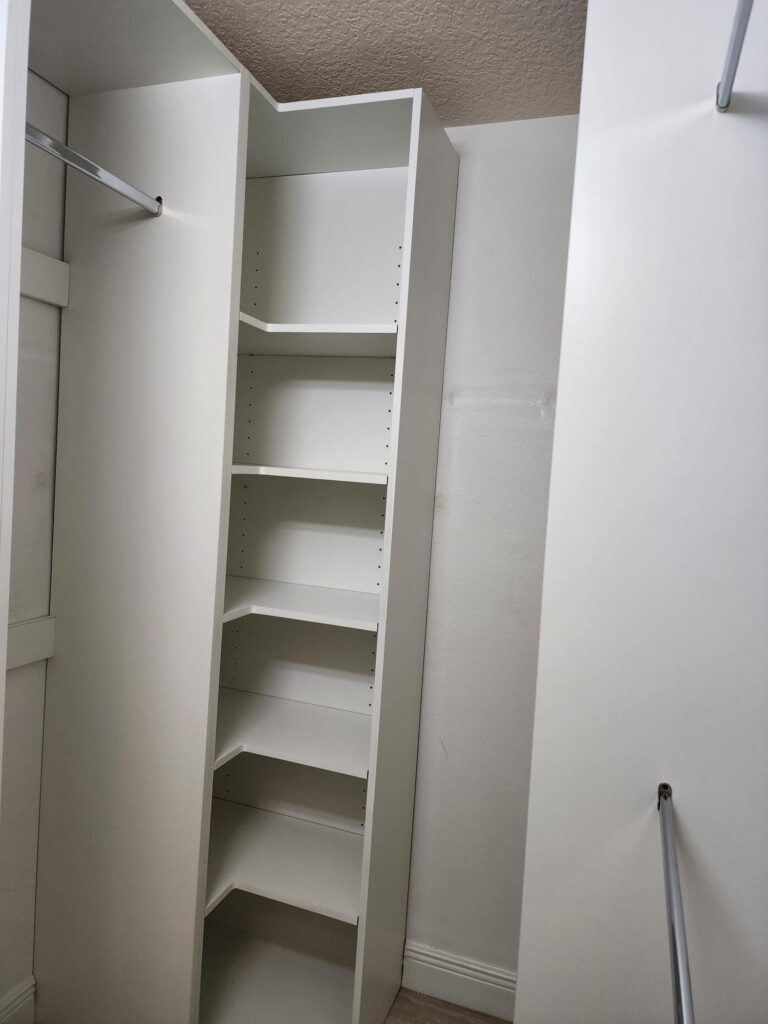 Custom white closet organizer with double hanging rods and adjustable shelves by Evolux Cabinets in Brevard County Florida.