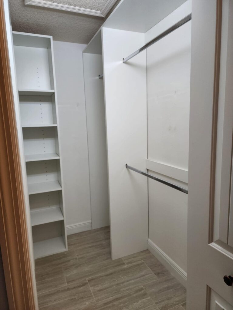 Custom white closet organizer with double hanging rods and adjustable shelves by Evolux Cabinets in Brevard County Florida.