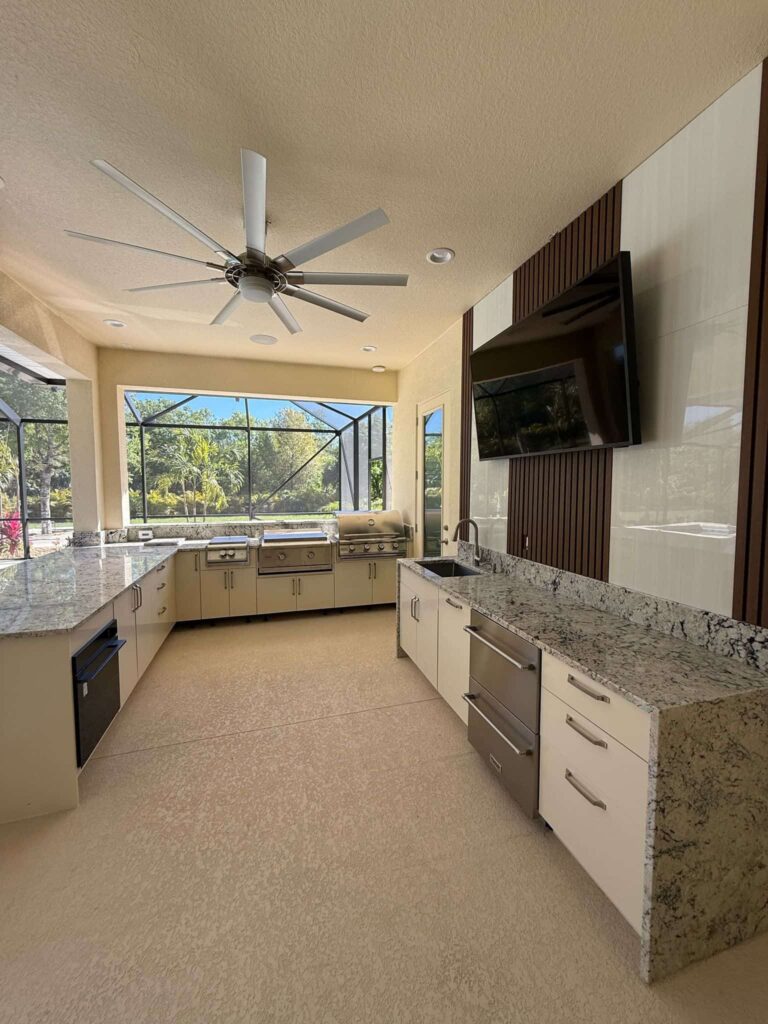 Outdoor kitchen with light beige waterproof cabinets, quartz countertops, and Blazer stainless steel appliances. Designed and built by Evolux Cabinets for elegant outdoor living.