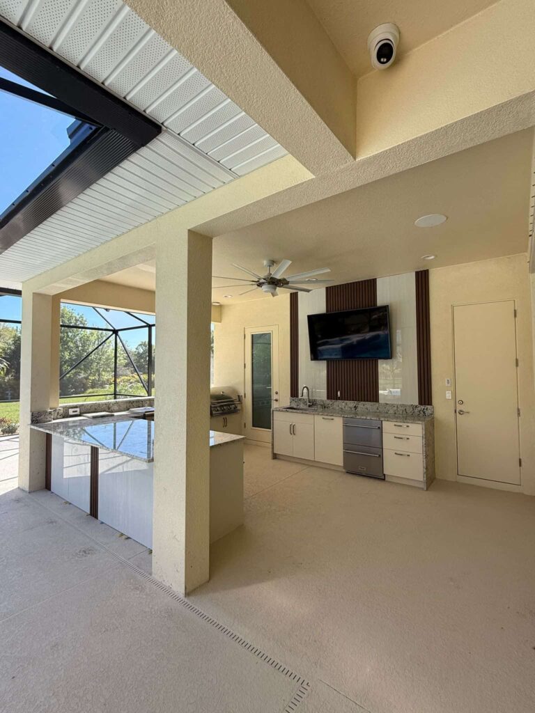 Outdoor kitchen with light beige waterproof cabinets, quartz countertops, and Blazer stainless steel appliances. Designed and built by Evolux Cabinets for elegant outdoor living.