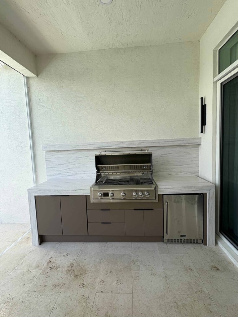 Modern outdoor kitchen with brown waterproof cabinets, Durasing countertop, and stainless steel grill. Built by Evolux Cabinets for stylish and durable outdoor living.