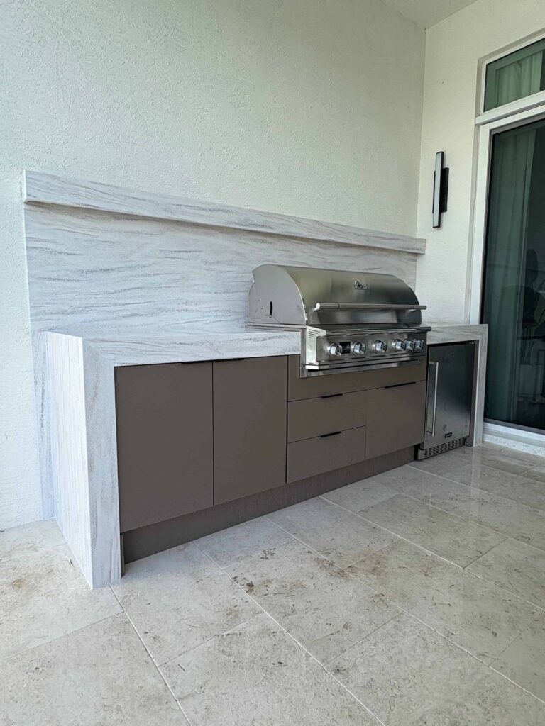 Modern outdoor kitchen with brown waterproof cabinets, Durasing countertop, and stainless steel grill. Built by Evolux Cabinets for stylish and durable outdoor living.