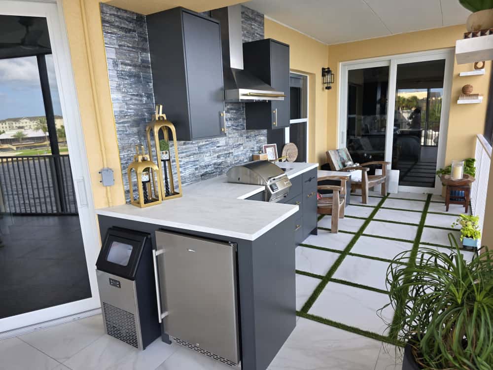 Modern outdoor kitchen with waterproof gray cabinets, Durasing countertop, and stainless steel range hood.